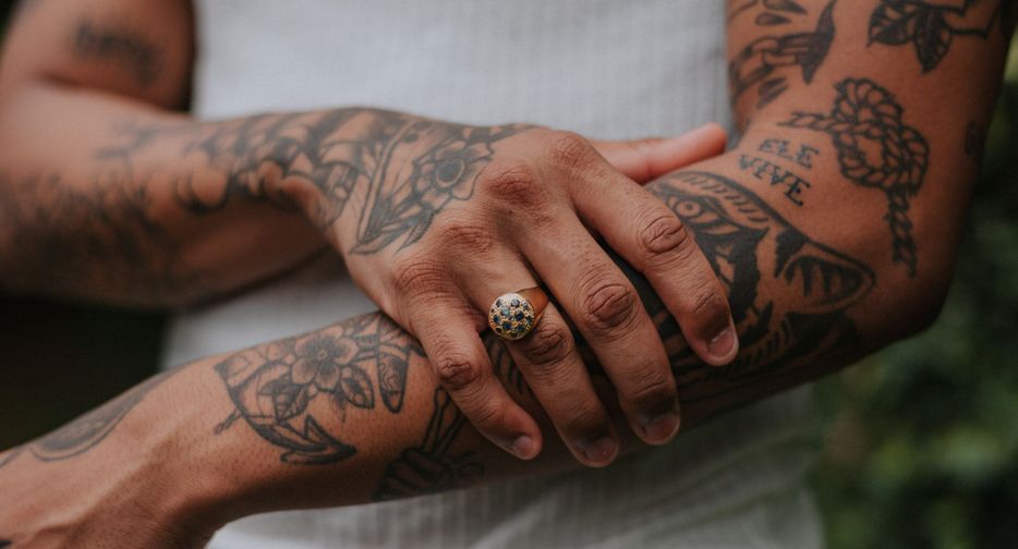 Person touching arm with a lot of tattoos