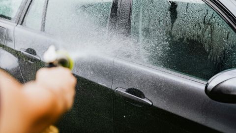 person cleaning the exterior of their car