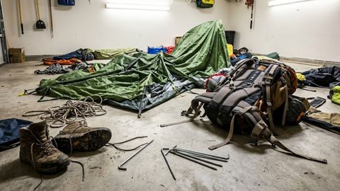 messy camping and hiking gear in garage 