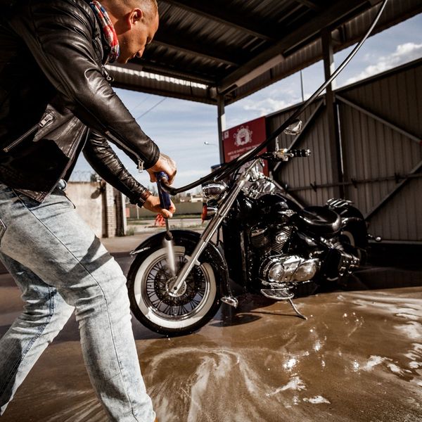 man washing a motorcycle