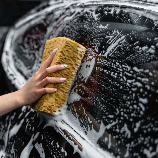 person cleaning car exterior