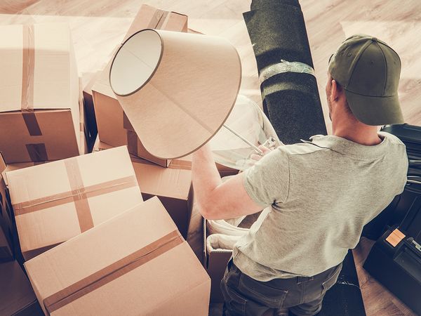 man holding a lamp with storage boxes all around him