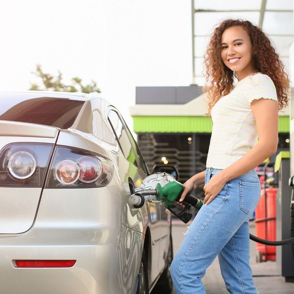 girl putting gas in car